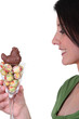 Photo: woman holding a glass full with Easter chocolate eggs woman holding a glass full with Easter chocolate eggs