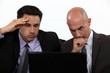 Stressed businessmen looking at laptop screen