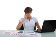 Photo: Woman sat at desk surrounded by graphs Woman sat at desk surrounded by graphs