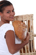 young black woman holding bread in her arms