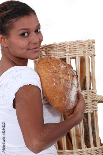 Photo: young black woman holding bread in her arms young black woman holding bread in her arms