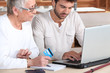 Foto: Man helping elderly family member shop on-line Man helping elderly family member shop on-line