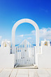 Beautiful white wooden door above aegean sea in Oia