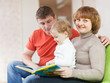 Happy parents with child looks the book