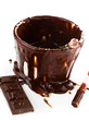 Cup of hot chocolate cocoa flow on white background, close up
