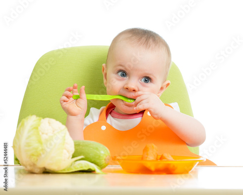 Photo: happy baby girl eating vegetables happy baby girl eating vegetables