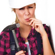 Junge Heimwerkerin mit Hammer hat Schmerzen am Finger