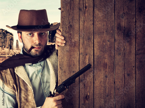 Photo: Bad gunman indicates with the gun a wooden plank Bad gunman indicates with the gun a wooden plank