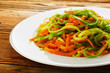 plate with mixed salad on the wooden table