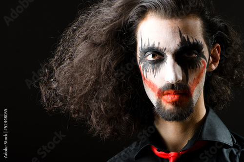 Photo: Joker personification with man in dark room Joker personification with man in dark room