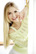 Young slim sexy woman in green sweater against the window