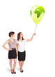 Foto: Happy ladies holding a green globe balloon Happy ladies holding a green globe balloon