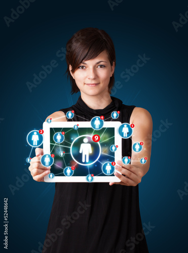 Photo: young woman holding tablet with social network icons young woman holding tablet with social network icons