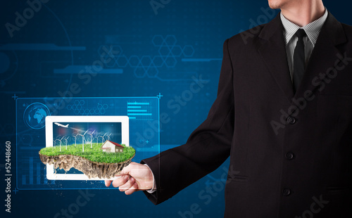 Photo: Businessman presenting a perfect ecology land with a house and w Businessman presenting a perfect ecology land with a house and w