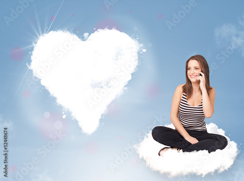 Photo: Beautiful lovely woman sitting on cloud with heart Beautiful lovely woman sitting on cloud with heart