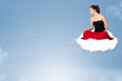 Young woman sitting on cloud with copy space