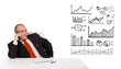Businessman sitting at desk with diagrams and making a phone cal