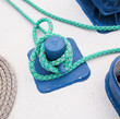 Close-up of mooring bollard with green rope in marina