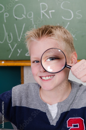 Photo: schüler schaut durch eine lupe schüler schaut durch eine lupe