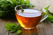 Foto: cup of tea with mint on a wooden table cup of tea with mint on a wooden table