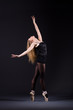 Ballerina dancing in the dark studio