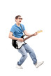 Full length portrait of a guy playing on an electric guitar