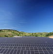 Solar photovoltaic cell panels on field under blue sky at Macedo