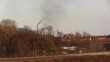Air pollution by dark smoke coming out of two factory chimneys.