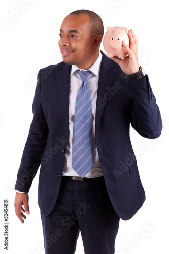 Photo: African American business man holding a piggy bank - African peo African American business man holding a piggy bank - African peo
