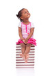 Cute black african american little girl seated in a stack of boo