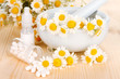 Medicine chamomile flowers on wooden table