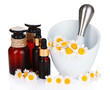 Essential oil and chamomile flowers in mortar isolated on white