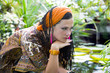 Blue-eyed woman with the african pigtails among tropical plants