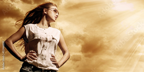 Photo: Beautiful woman over sky background Beautiful woman over sky background