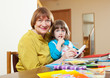 Mature woman and  girl drawing with  pencils