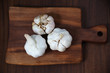 Three Garlic bulbs on the wooden cutting board