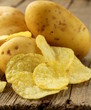 Photo: natural potato chips and fresh potato on a wooden background natural potato chips and fresh potato on a wooden background