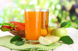 Glasses of juice, apples and carrots