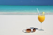 Orange juice and sunglasses on the beach. Exuma, Bahamas
