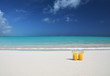 Two glasses of orange juice on the sandy beach