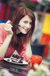 Style redhead girl with cup and cake