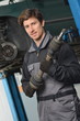 Auto Mechanic is working in car repair shop.