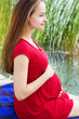Photo: Young attractive pregnant woman enjoying near lake Young attractive pregnant woman enjoying near lake