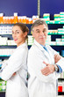 Foto: Apotheker Team in Apotheke vor Medikamenten Apotheker Team in Apotheke vor Medikamenten