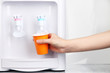 Woman filling cup at water cooler
