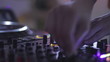 Close-up of female dj hands at the deck controls in night club.