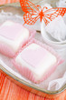 heart shaped pink cupcakes in  tin tray with spoons , red backgr