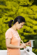 Mature woman ready to apply paint on outdoor deck railings