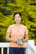 Mature woman relax while painting outdoor deck railing