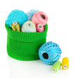 Colorful yarn for knitting in green basket isolated on white